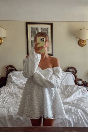 Vit offshoulder kortklänning med spets - Supersöt vit kortklänning med offshoulder och puffiga långärmar, går alltså att välja om klänningen ska va off shoulder eller inte. Klänningen har ett spetsmönster över hela tyget, helt ny endast testad! Kom privat för fler bilder!🩷