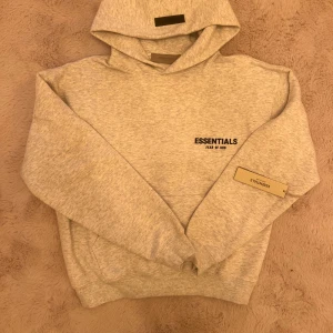 Essentials Fear of God hoodie - Helt ny Fear of God hoodie I light oatmeal färg.        Aldrig använts innan fick som en present på 25 november.  Storlek XS. Säljer för att den är liten på mig, är cirka 180. Passar dig perfekt om du är runt 175.