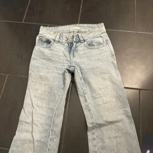 Ljusblå bootcut jeans från gina  - Säljer ett par ljusblå Levis jeans med bootcut passform. Klassisk femficksmodell med dubbla knappar i midjan och snygga bakfickor med knappdetalj. Perfekta för dig som gillar retrovibbar och avslappnad stil.