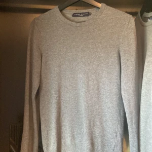 Grå kashmirtröja från Libero Milano - Mjuk och stilren grå tröja i kashmir från Libero Milano. Klassisk rund halsringning, ribbade muddar och lång ärm. Perfekt för dig som gillar en clean och tidlös look med lyxig känsla. Väl använd, skicket är bra!