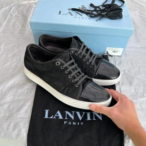 Lanvin - Säljer ett svart par Lanvins med lackad tå, i bra skick, storlek 45, uk11, det är sprillans nya snören på, man får med, box Dustbag och extrasnören, lite använt mocka på vissa ställen och sulan är lite använd, och en jätteliten defekt på captoen som inte ens syns på bilderna, sulkräm har använts, pris går att diskutera✅