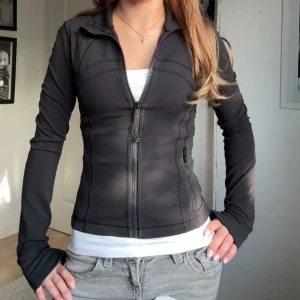 Define jacket från Lululemon - Jättefin cropped Lululemon define jacket i storlek 2, materialet Nulu, säljes för att jag har 2 och använder inte denna. Använd sparsamt och väldigt lite, nypris 1280kr, mitt pris 990kr. Skriv vid frågor eller funderingar. Obs, jag har klippt bort lappen i nacken. 