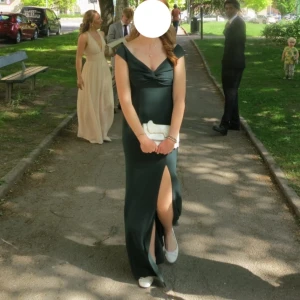 Grön balklänning - Säljer min fina balklänning, har aldrig känt mig så fin som med denna på. Tyvärr regnade det på min bal vilket gjort att den är lite fläckig i nederkant (se bild 5). Det går säkert bort om man tvättar den o ger den lite kärlek, sen är det som sagt längst ner så syns inte jättemycket när den sitter på (alternativ att du syr upp den om du är kortare). Jag är 171 och hade platta ballerina på mig. Om du har frågor eller önskar fler bilder så är det bara att skriva!!😊