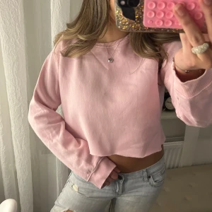 Ljusrosa croppad sweatshirt - Superfin ljusrosa croppad sweatshirt som jag köpte som ”avklippt” nertill med långa ärmar. Det är fint att ha linne under också! Storlek M.