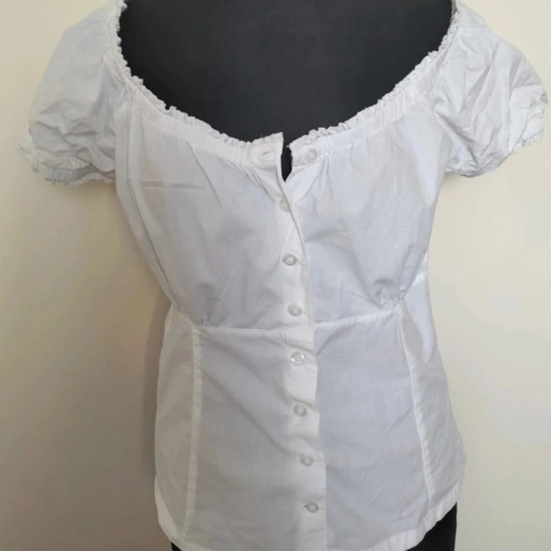 vit topp med knappar