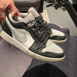 Nike Air Jordan 1 Low svart/vit/ grå - Säljer då de inte använts på ca 3 år. Lite slitna vid insidan av skorna (se 2a bilden) men annars i bra skick. Inget kvitto elr box är med.