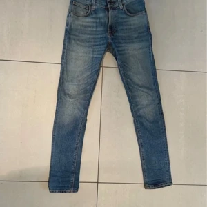 Blå nudie jeans  - Säljer ett par klassiska blå nudie skinny jeans men skulle inte säga att de sitter som skinny jeans. Jeansen är i bra skick och har inte använts mycket. Storlek 32L 27W