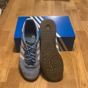 Adidas Spezial blå sneakers mocka - Adidas Spezial sneakers i ljusblå mocka med vita klassiska ränder och snörning. Snygg retrostil med platt sula och rund tå. Yttersulan är brun och har ett unikt mönster. Perfekt för dig som gillar streetwear och sportig vibe. Det är inga problem med skorna och inga märken. Pris kan diskuteras vid snabb affär🚚♻️