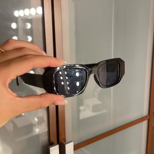 Svarta solglasögon från Bik Bok - Snygga svarta solglasögon från Bik Bok med rektangulära, chunky bågar i blank plast. De har mörka glas och en cool, modern vibe som passar perfekt till streetstyle eller när du vill sticka ut lite extra.