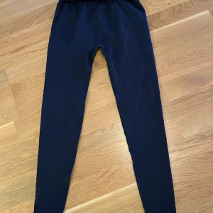 Ny Mörkblå ribbade leggings från H&M Move - Säljer ett par mörkblå ribbade leggings från H&M Move i storlek S. De har en hög midja och är tillverkade i ett stretchigt material som passar perfekt för träning eller chill. Snygg passform och riktigt bekväma! Oanvänd 