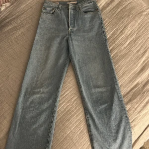 Levi's Ribcage Straight ljusblå jeans - Levi's Premium Ribcage Straight jeans i ljusblå tvätt. Klassisk femficksmodell med hög midja och raka ben. Jeansen är tillverkade i bomull och har snygga kontrastsömmar och Levi's ikoniska läderpatch bak.