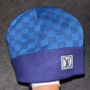 Blå rutig mössa - Blå rutig mössa med bokstäverna L och V