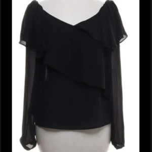 Svart blus från Gina Tricot - Säljer en svart ”Stockholm stil” blus från Gina Tricot i storlek 34. Blusen har långa, transparenta ärmar och snygga volangdetaljer framtill. Offshoulder-modell som ger en cool och trendig look. Perfekt för dig som gillar stilrena och feminina plagg.