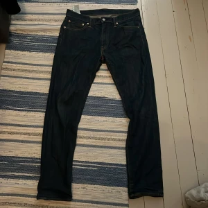 Levi's 508 mörkblå jeans 32/32 - Mörkblå Levi's 508 jeans med klassisk femficksdesign och raka ben. Snygga kontrastsömmar och läderpatch bak i midjan. Jeansen är tillverkade i slitstarkt denim och har en tidlös look som passar till det mesta.