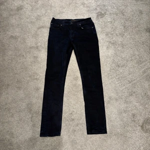Nudie jeans - Snygga mörkblå jeans från Nudie Jeansen har smal passform, normal midja och är tillverkade i mjukt denimtyg. Perfekta för dig som gillar en stilren och enkel look. Även snyggt mönster. Skick 9/10 pris går att diskuteras passar även W27 L30-31