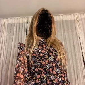 Blommig volangblus från Lindex🥰 - Supersöt blus från Lindex med blommigt mönster i rosa, blått, gult och lila på svart botten. Blusen har volangdetaljer vid axlar och bröst, långärmade transparenta ärmar och en lätt, luftig känsla. Perfekt för dig som gillar färg och romantiska detaljer ✨🥰✨💖💖