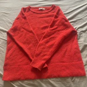 Orange Ull stickad tröja från Indiska - Mysig orange Ull stickad tröja från Indiska med rund halsringning och breda ribbade muddar vid ärmslut och nederkant. Perfekt för lager-på-lager och chill dagar. Enkel och stilren design som funkar till allt. Lite nopprig men absolut inget som stör❤️