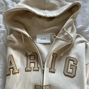 Axel arigato hoodie - Säljer min Axel Arigato ”legend” zip hoodie i färgen biege 🤩 Den är sparsamt använd, storlek Medium men sitter aningen större. Nypris på denna låg på ca 3000kr när jag köpte den om jag kommer ihåg rätt.  Hör av er vid mer frågor och bilder!