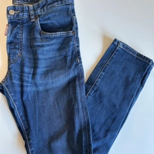 Dsquared2 jeans - Säljer ett par blå  jeans från Dsquared2 med klassisk femficksdesign och snygga detaljer. Jeansen har normal midja och är tillverkade i stretchig denim för en bekväm passform. Perfekta för dig som gillar en smal siluett och stilren look.