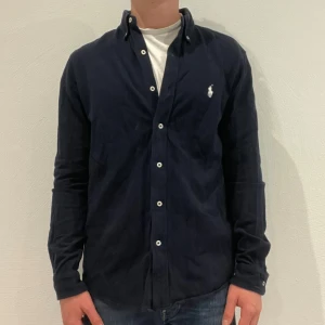 Marinblå Ralph Lauren skjorta - Marinblå  Ralph lauren skjorta || Storlek M || Skjortan är i bra skick || modellen på bilden är 170cm och väger 62kg || Tveka inte på att höra av dig vid frågor eller funderingar 