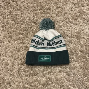 Nikben mössa - Vit och mörkgrön Nikben mössa med texten OFF SEASON