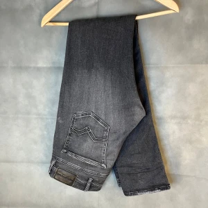 Replay jondrill jeans i storlek W34/L34 - Replay jondrill jeans i storlek W34/L34. Svarta sten tvättade jeans med skön passform och lite stretch som gör dem bekväma. Bra skick utan hål eller fläckar, bara lite slitningar. Nypris runt 1500–2000 kr. Mått: A: 37 cm, B: 24 cm, C: 13 cm, D: 78 cm. Modellen är ca: 172cm, väger: 56kg.  Säljes för 499 kr.  