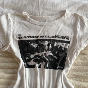 Brandy melvillevit Radio Silence t-shirt - Vit t-shirt från Brandy Melville med svart tryck framtill. Är super fin och passar perfekt nu inför hösten med en kappa!🍁💕Storlekn är one-size men skulle säga att den passar xs-s. Den har en lite fläck som går bort i tvätten!