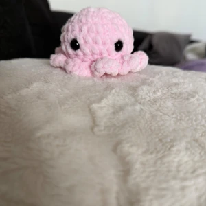 Rosa bläckfisk  - Bilderna visar en söt, handgjord rosa bläckfisk i mjukt garn. Den är i mycket fint skick utan synliga defekter eller slitage. Perfekt som present eller dekoration.