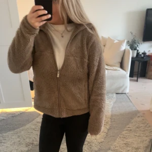 Beige/brun teddyjacka  - Mysig beige teddyjacka med dragkedja framtill. Köpt från lager 157 och använd rätt många gånger men det är knappt något som syns.
