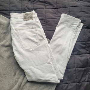 Vita Replay jeans l - Snygga vita jeans från Replay. Replay-logga på bakfickan och silverfärgade detaljer. Sitter skönt hela dagen. Perfekta för dig som vill sticka ut med stilrena jeans.