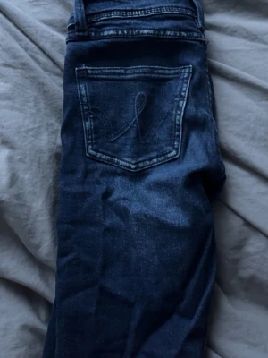 Mörkblå jeans från Gina tricot - Säljer ett par mörkblå jeans från Gina tricot med klassisk femficksdesign och snygga kontrastsömmar. Jeansen har en normal passform och är tillverkade i slitstark denim med diskret tvättad look. Perfekta till vardagsstilen!