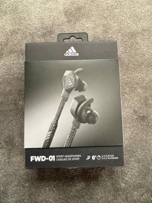 Adidas FWD-01 sporthörlurar - Säljer ett par Adidas FWD-01 trådlösa hörlurar i svart! Dessa är helt nya (tyvärr inget kvitto)! Ljudkvalitén på dessa är väldigt bra, de kopplar enkelt till bluetooth, och de är perfekta för atleter som tränar hårt! Köpte dessa för 1600kr något år sedan på adidas officiella hemsida. Säljer dem nu för 1000kr! Skriv vid funderingar!