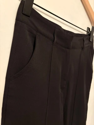 Madlady kostymbyxor tall - Säljer ett par kostymbyxor från Madlady i svart, köpta på vi*ted men för små för mig. Tjejen innan mig hade använt de få gånger. Anpassade för långa ben. Tjejen som köpte dem har dessutom sprättat upp botten, lätt att sy igen själv. Går att klä upp, klä ner och ha på jobb! Skick enligt bilderna ✨ Tror de är low waist men kan vara mid waist. Fråga om mått vid osäkerhet   Midja: 34 Längd: 34       