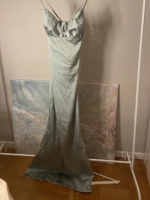 Ljusblå långklänning med cut-out - Jättefin ljusgrön balklänning. Endast testad då jag hade två klänningar och valde en annan. Jag är 174cm lång och den är någorlunda kort men funkade jättebra att ha ballerina skor och klackar med. 