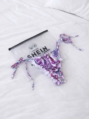 Nya lila mönstrad bikiniunderdel från SHEIN, strlk S - Helt ny och oanvänd lila bikiniunderdel med mönster från SHEIN i storlek S. Den har knytning i sidorna vilket gör den justerbar i midjan för optimal passform. Ett stilrent och somrigt plagg som passar perfekt för strand eller pool. Köptes för nypris 109kr! FÖRST TILL KVARN!