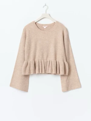 Beige stickad volangtröja - Supersöt beige stickad tröja från ginatricot (14+) med volangdetalj nedtill och vida ärmar. Tröjan har en croppad passform och rund halsringning. Oanvänd, endast provad på. 