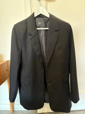 Svart kavaj från BikBok - Stilren svart kavaj från BikBok med klassisk passform, två knappar framtill och fickor. Den är i Xs men i en oversize storlek. 