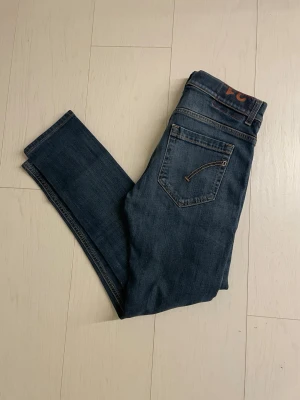 Mörkblå skinny jeans - Snygga mörkblå  jeans med klassisk femficksdesign och kontrastsömmar. Dondup George 