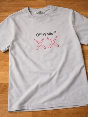 Off-White grå t-shirt med tryck - Säljer en grå t-shirt från Off-White med svart och rosa tryck framtill och stort grafiskt tryck på ryggen. T-shirten har rund hals och korta ärmar. Materialet känns som mjuk bomull och passformen är normal. Perfekt för dig som gillar streetwear och coola prints.