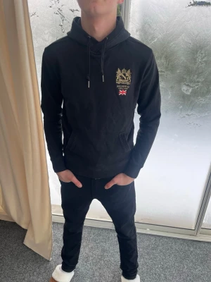 Svart hoodie från Morris - Riktigt snygg svart hoodie från Morris. Mycket bra skick. Strl S. Personen på bilderna är 183 cm lång. Skicka gärna prisförslag. Fraktas dagen efter köp