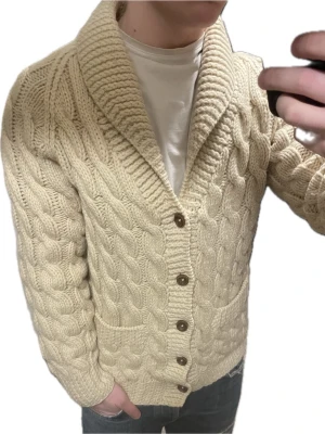 Beige stickad cardigan - Otroligt snygg beige kabelstickad cardigan. Passar perfekt till kallare väder. Modellen är 180cn, 75kg. Priset kan såklart diskuteras
