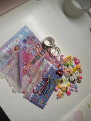 Stort pysselkit med stickers och pärlor - Ett färgglatt pysselkit med massor av söta stickers, pärlarmband, små dekorationer i form av djur och figurer, washitejp, plastbrickor i olika former och en lila penna. Perfekt för dig som gillar att pyssla och dekorera med kawaii-tema.