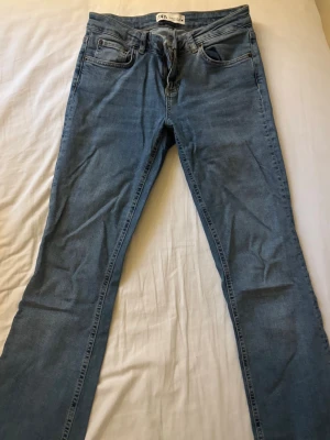 Blå jeans från Zara - Säljer ett par jeans från Zara, lågmidjade med stretch. Går ut vid benen. Använda 3 gånger