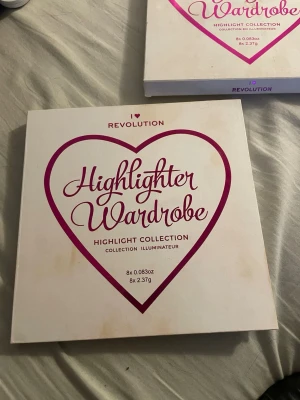 I Heart Revolution Highlighter Wardrobe - Highlighter Wardrobe-palett från I Heart Revolution med åtta olika nyanser i guld, champagne, rosa och brons. Paletten har rundade puder i pressad form och kommer i en vit ask med hjärtdesign. Perfekt för att skapa glow och highlighta ansiktet.