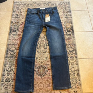 Blå raka jeans med klassisk tvätt - Snygga blå jeans från Pier one med rak passform och klassisk tvätt. Jeansen har fem fickor, bälteshällor och knappgylf. Materialet är denim i bomull och de har en tidlös look som passar till det mesta. Jeansen är helt nya och säljer för att de inte passade.