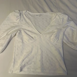 Vit omlottopp från Kappahl - Säljer en superfin vit omlottopp från Kappahl i storlek M. Toppen har trekvartsärmar och ett diskret broderat mönster. 💫
