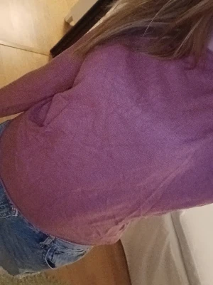 Ljuslila långärmad tröja - En enkel och mjuk ljuslila långärmad tröja i tunt material. Tröjan har rund halsringning och avslappnad passform, perfekt att matcha med jeans eller kjol. Inga synliga loggor eller mönster, bara clean och stilren look.