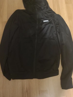 Svart McKenzie  - Svart hoodie från McKenzie med dragkedja framtill och huva. Äkta helt ny