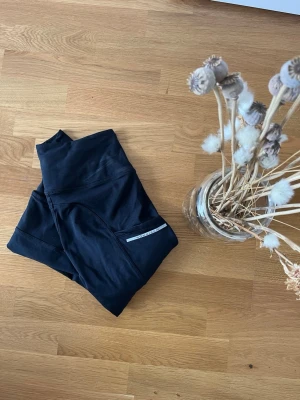 Svarta fodrade träningsbyxor från Röhnisch XS - Nypris: 800 kr. Snygga svarta leggings från Röhnisch i storlek XS. De har en stilren design med diskret logga på benet och är tillverkade i ett stretchigt material som passar perfekt till träning eller chill. Hög midja för extra komfort. Fodrade. 