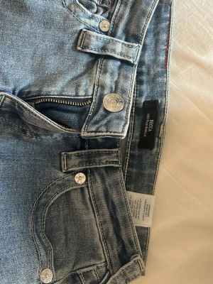 True Religion Jeans Becca  - Säljer ett par ljusblå jeans från True Religion i modell Becca. De är inte använda ofta så de är i bra skick. De är även uppsydda och passar mig som är 161 cm. Skriv för frågor!
